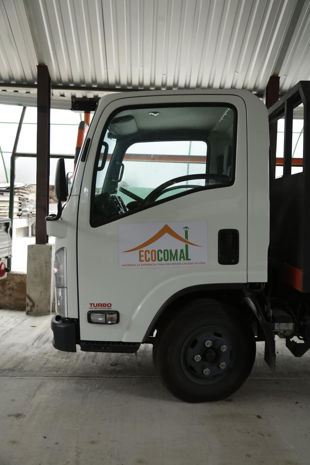Camión de reparto rotulado con el logotipo de Ecocomal
