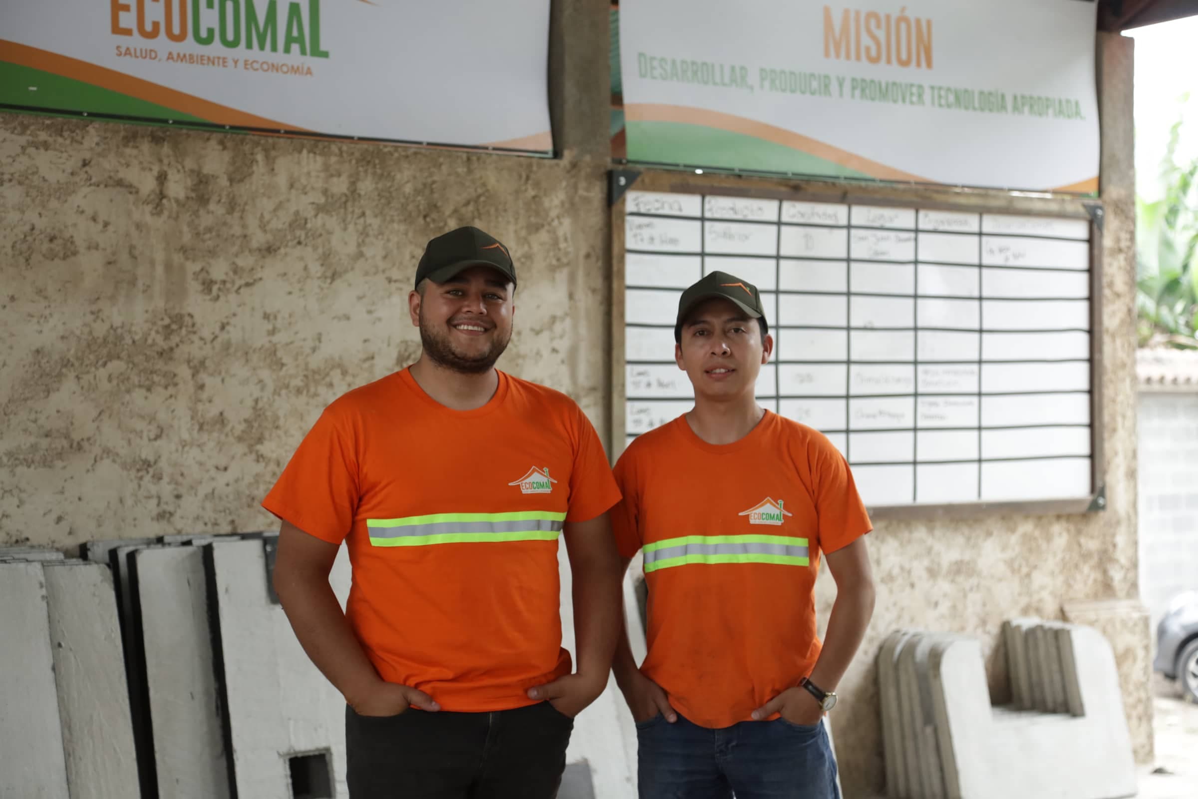 Dos operarios de Ecocomal en la planta, junto a cuerpos de estufa terminados